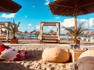 a beach with chairs and umbrellas on the sand at Sea view apartment in Tsarevo