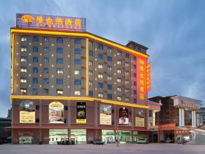 a large building with a sign on top of it at Vienna Hotel Guangxi Fangcheng in Fangcheng