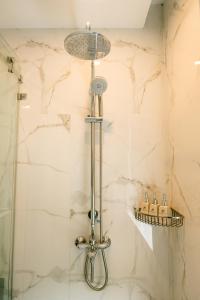 una ducha con cabezal de ducha en un baño en Marigold Hotel Hanoi, en Hanói