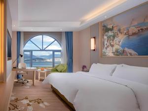 a bedroom with a large white bed and a window at Vienna Hotel Yunnan Dali Erhai Lake in Dali