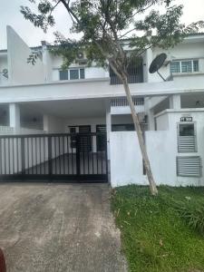 Un edificio blanco con un árbol delante. en Medina Luxe Stay, en Kota Bharu