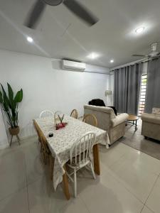 una sala de estar con una mesa y un sofá en Medina Luxe Stay, en Kota Bharu