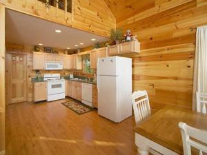 Il comprend une cuisine avec un réfrigérateur blanc et des murs en bois. dans l'établissement A Slice of Heaven Holiday home, à Sevierville