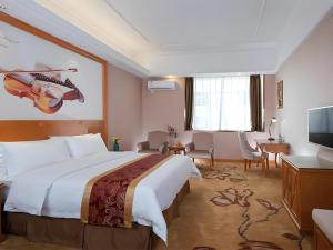 a hotel room with a bed and a flat screen tv at Vienna Hotel Guangdong Dongguan Chengnan Station in Dongguan