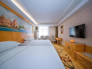 a hotel room with two beds and a flat screen tv at Vienna Hotel Hubei Xiaogan Beijing Road in Xiaogan