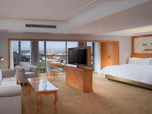 a hotel room with a bed and a flat screen tv at Vienna Hotel Guiyang North Station Dream City in Guiyang