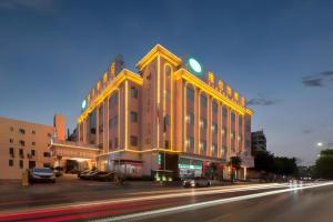 a large building with a clock on it on a street at Vienna Hotel Guangdong Foshan Wenhua North Road in Nanhai