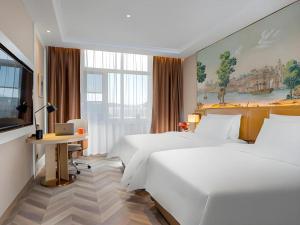 ein Hotelzimmer mit zwei Betten und einem Schreibtisch in der Unterkunft Vienna Hotel Beijing Changping Science and Technology Park in Ch'ang-p'ing-hsien + 150 Fotos