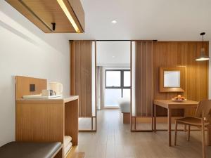 a kitchen and living room with a table and chairs at Meijin All Suites Hotel Suzhou in Suzhou