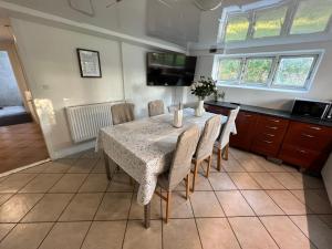 a dining room with a table with chairs and a tv at Casa de Rainer Copenhagen Room 2 in Copenhagen