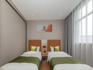 two beds in a room with a window at Shell Hotel Shnaghai Beiqiao Metro Station in Shanghai +161 photos