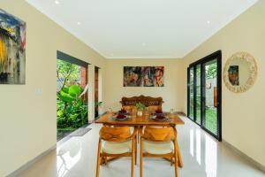 Un comedor con una mesa de madera y dos sillas. en Novancha Villa, en Ubud