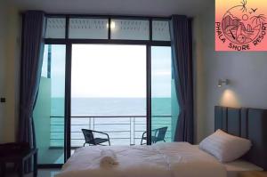 a bedroom with a bed and a view of the ocean at Phala Shore Resort in Ban Phala
