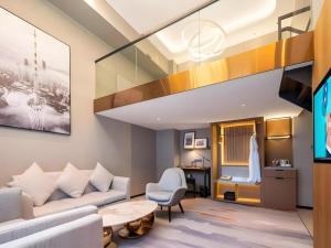 a living room with a couch and a table at Park Inn Guangzhou Railway Station Yuexiu International Convention Center in Guangzhou