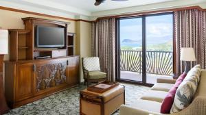 ein Wohnzimmer mit einem TV und einem Balkon in der Unterkunft Aulani, A Disney Resort And Spa in Kapolei
