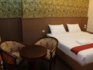 a room with a bed and two chairs and a table at The Grace Residence in Surin +190 photos