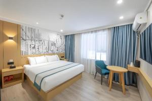 a hotel room with a bed and a desk and a table at City Comfort Inn Hengyang Baishazhou in Hengyang