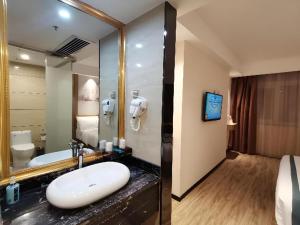 a bathroom with a sink and a large mirror at City Comfort Inn Suichuan County Government Pedestrian Street in Suichuan +149 photos