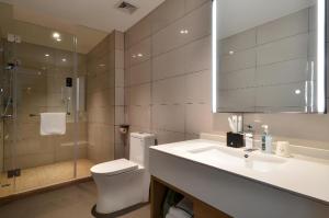 une salle de bain avec toilettes, lavabo et douche dans l'établissement City Comfort Inn Yichang Sanxia Airport, à Ku-lao-pei