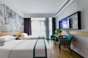 une chambre d'hôtel avec deux lits et une télévision dans l'établissement City Comfort Inn Yichang Sanxia Airport, à Ku-lao-pei