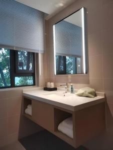 a bathroom with a sink with a mirror and two windows at City Comfort Inn Nanyang Nanshi Hospital in Nanyang +188 photos