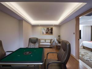 ein Zimmer mit Billardtisch und ein Schlafzimmer in der Unterkunft Vienna Hotel Shenzhen Guanlan Shanshuitianyuan Xintian in Tiantangwei