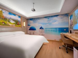 a bedroom with a large white bed and a desk at Vienna Hotel Tianjin Olympic Sports Center Tianta in Tianjin