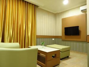 a waiting room with a tv and a table and chairs at Hotel Menara Lexus in Polonia Airport