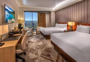 a hotel room with two beds and a desk at Atlantis Casino Resort Spa in Reno +103 photos