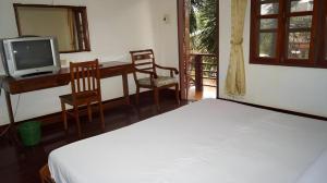 a bedroom with a bed and a desk and a tv at Champa Residence Hotel in Pakse