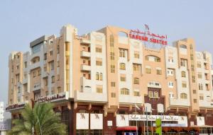 a large building with a red sign on it at Safeer Hotel Suites in Muscat