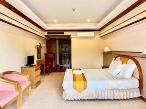 ein Hotelzimmer mit Bett und Schreibtisch in der Unterkunft Supar Royal Beach Hotel in Ban Plau