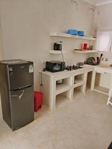 Una cocina con un refrigerador y una mesa dentro. en palm villa, en Watamu