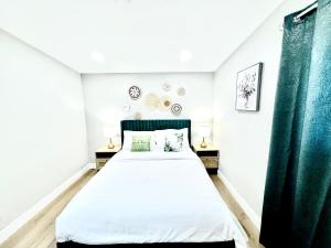 a bedroom with a large bed with green curtains at Xlnc Exotic home13824 Powers Rd in Poway