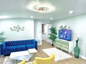 a living room with a blue couch and a tv at Xlnc Exotic home13824 Powers Rd in Poway