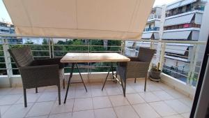 a table and chairs on the balcony of a building at Tenios Urban nest retreat in Kalamata
