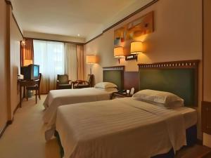 a hotel room with two beds and a desk at Friendship Hotel in Shenzhen