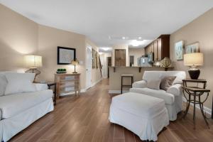 a living room with two white couches and a kitchen at Lakeside 312 at Bluewater Bay Resort in Niceville