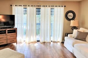 a living room with a couch and a large window at Lakeside 312 at Bluewater Bay Resort in Niceville