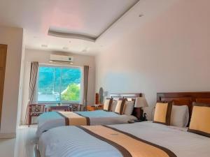 a bedroom with two beds and a window at Ngoc Bach Hotel in Mai Chau
