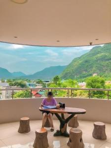 a woman sitting at a table with a view at Ngoc Bach Hotel in Mai Chau