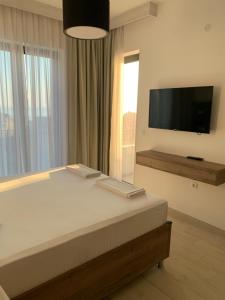 a bedroom with a bed and a flat screen tv at REZEVICI BOUTIQUE VILLA in Petrovac na Moru