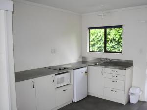 una cucina bianca con lavandino e finestra di Oxford Court Motel a Nelson