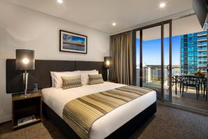 una camera d'albergo con un letto e un balcone di Quest East Perth a Perth Altre 30 foto