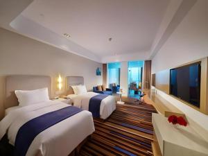 a hotel room with two beds and a flat screen tv at Holiday Inn Express Nantong Downtown By IHG in Nantong +70 photos