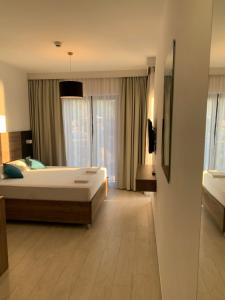 a bedroom with a large bed and a large window at REZEVICI BOUTIQUE VILLA in Petrovac na Moru
