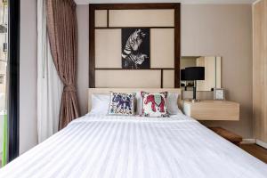 a bedroom with a large white bed with pillows at Palm Spring Condo Nimman - Deluxe 810 in Chiang Mai +26 photos