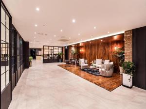 a lobby with couches and chairs in a building at Daejeon Namoo Hotel in Daejeon