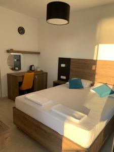 a bedroom with a large bed with a desk and a chair at REZEVICI BOUTIQUE VILLA in Petrovac na Moru