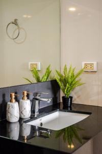 a bathroom counter with a sink and a mirror at Palm Spring Condo Nimman - Deluxe 810 in Chiang Mai